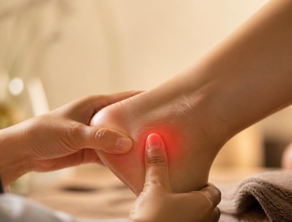 Close-up of a person pressing on a painful heel